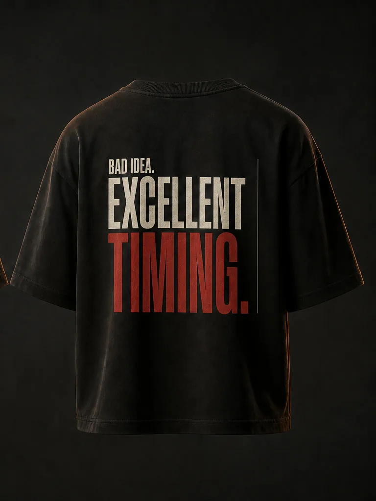 Back of the tee in condensed capitals: Bad idea, in bone, above Excellent timing, in oxide red.