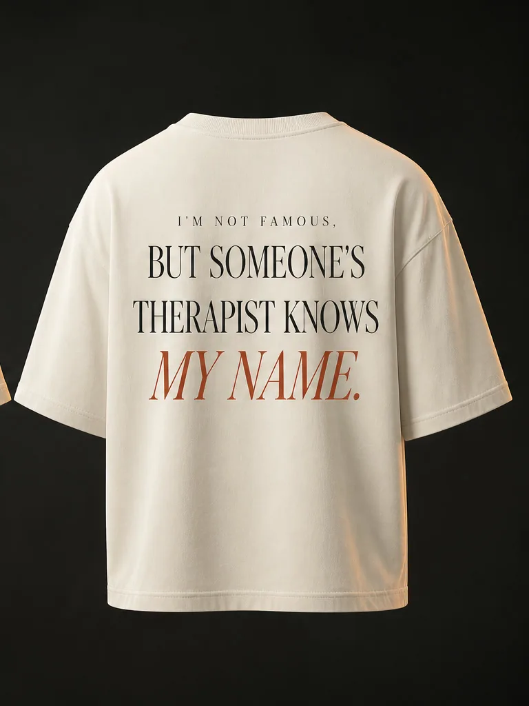 Back of the tee in a black serif: I'm not famous, but someone's therapist knows my name, with the last line in oxide italic.